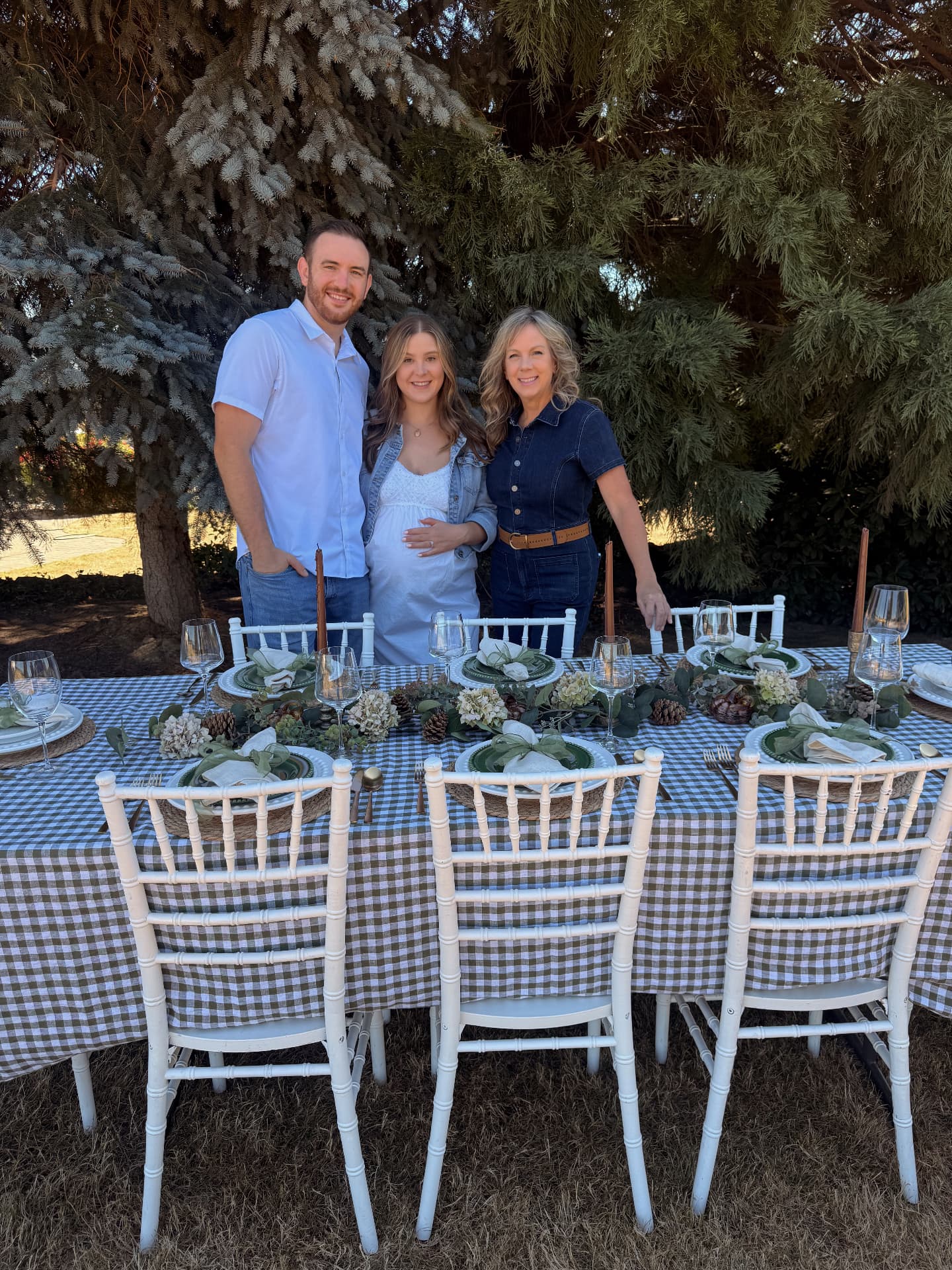 Jacob, Makayla, and Joyce — the family founders of Set The Scene Portland — behind a curated gingham tablescape