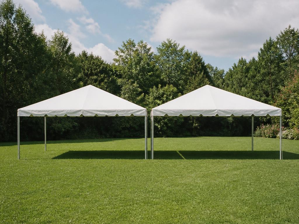 Two white 10 by 20 foot event tents on a lawn at golden hour