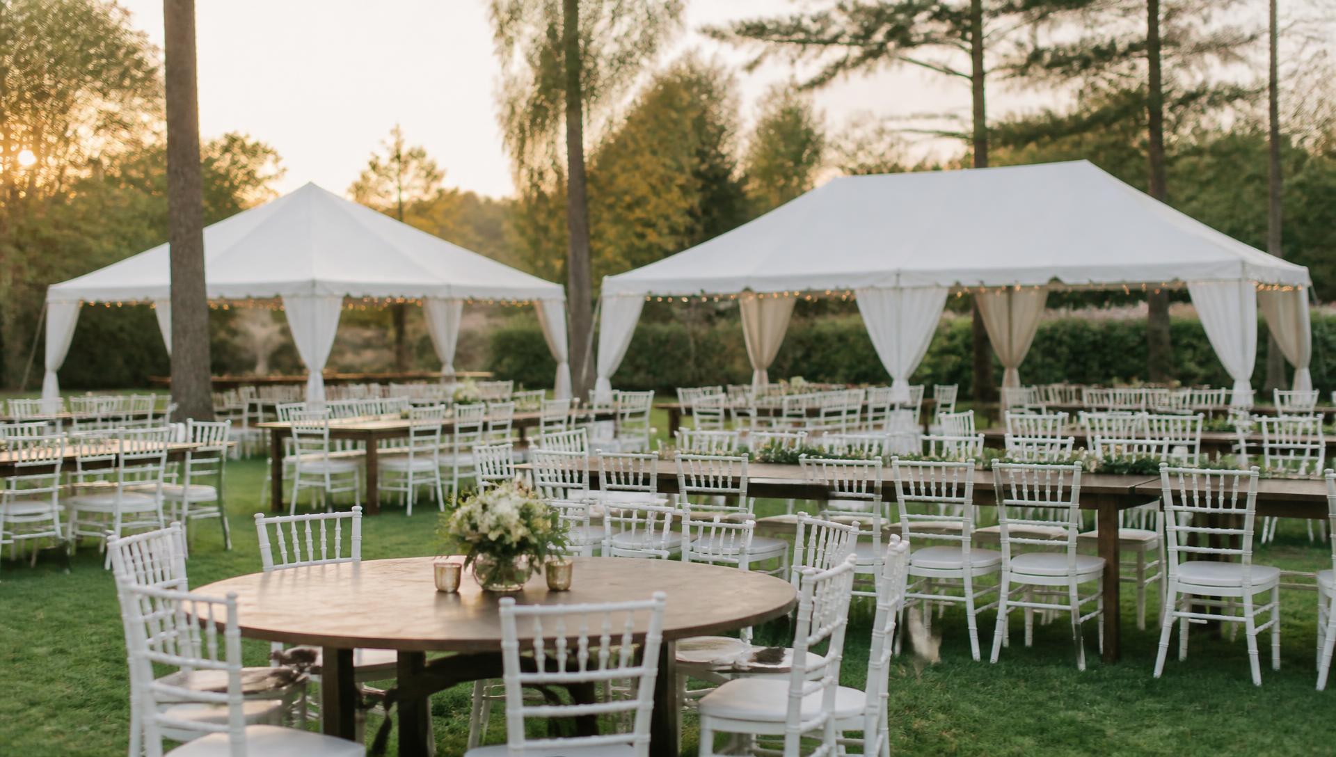 White chiavari chairs and tables under an elegant white tent